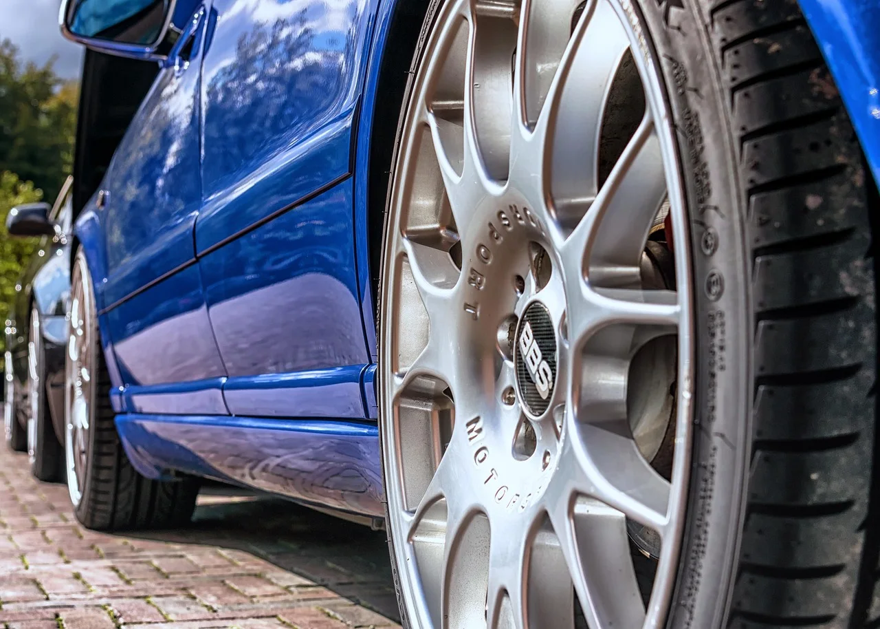 Glänzende Leichtmetallfelge an einem gepflegten blauen Fahrzeug